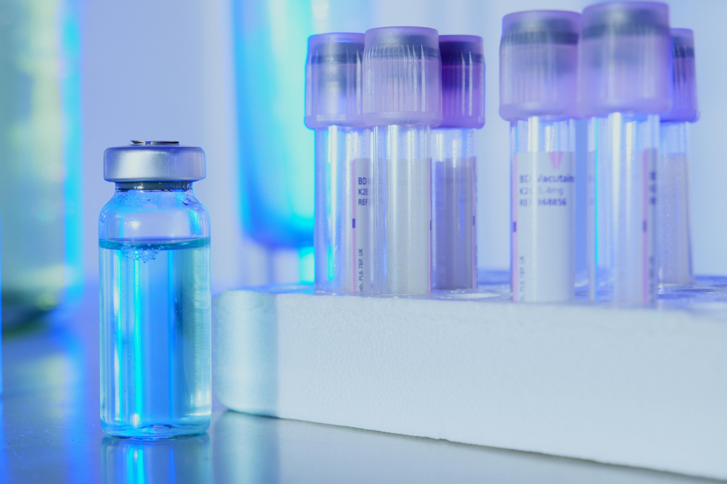 Laboratory vials representing clinical trial testing phases, with a focus on NAD+ research.