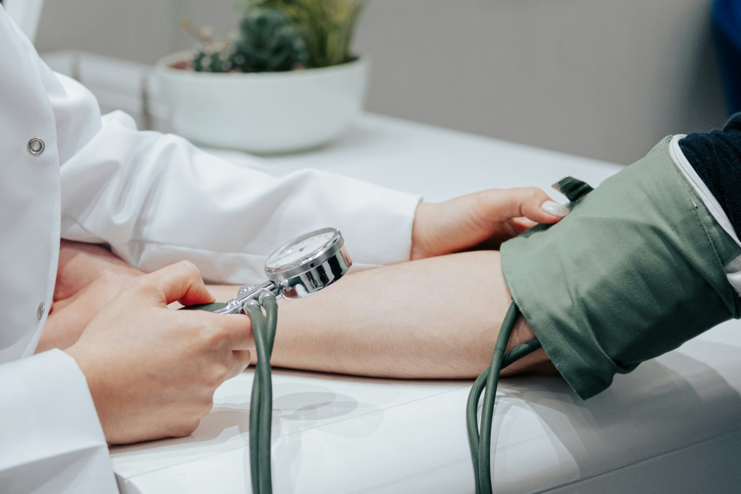 Doctor measuring patient's blood pressure to illustrate nicotinamide riboside (NR) benefits for cardiovascular health.