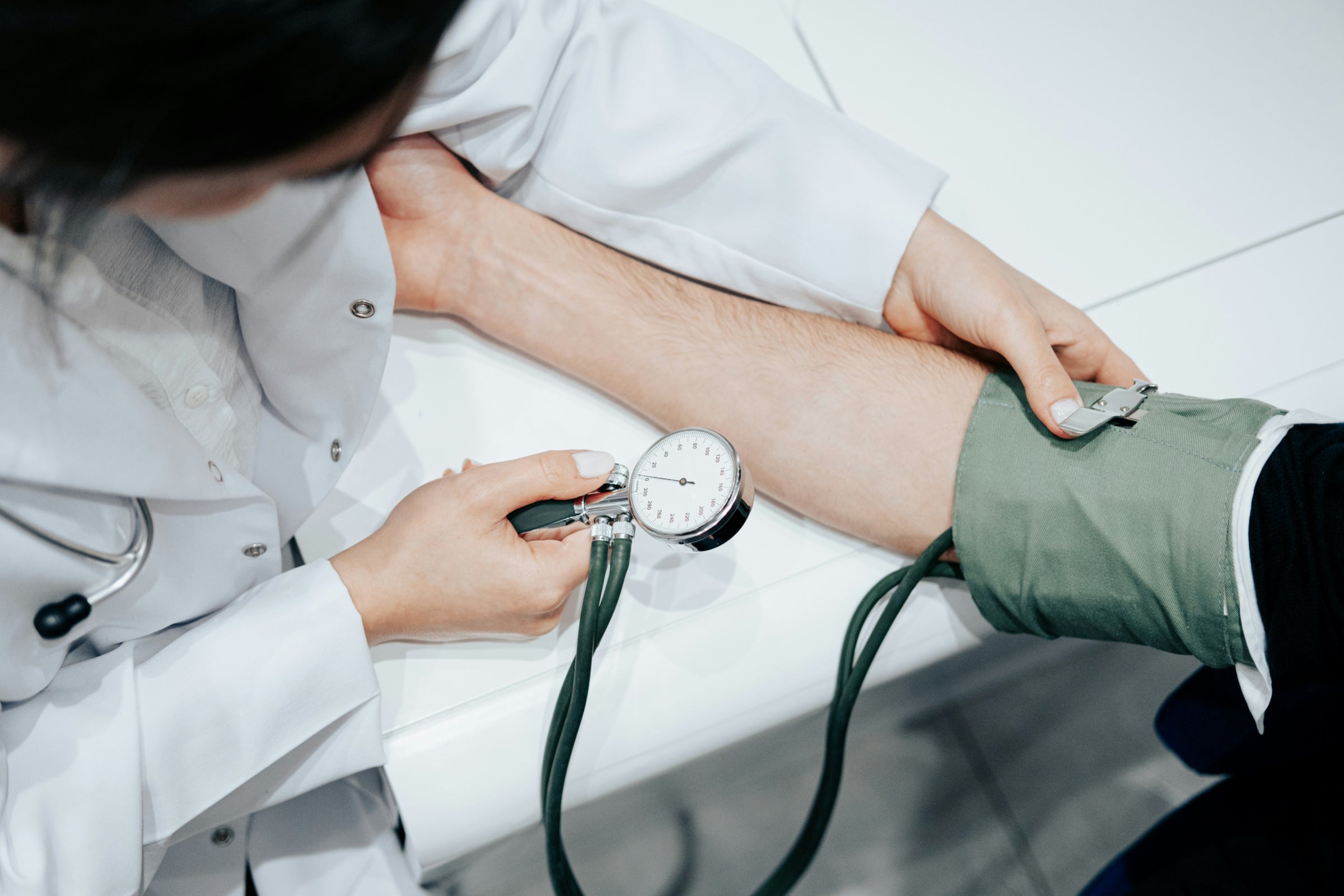 Doctor measuring blood pressure symbolizing NAD+ and cardiovascular health research in heart failure patients.