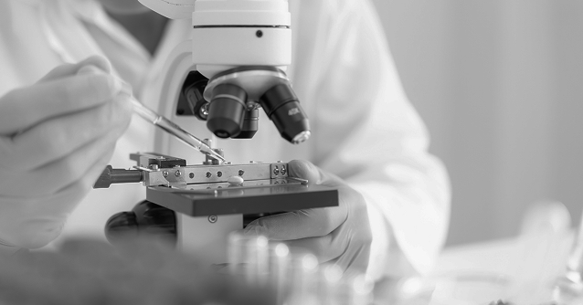Scientist using a microscope to study NAD+ research and its role in aging, metabolism, and disease in the 2010s.