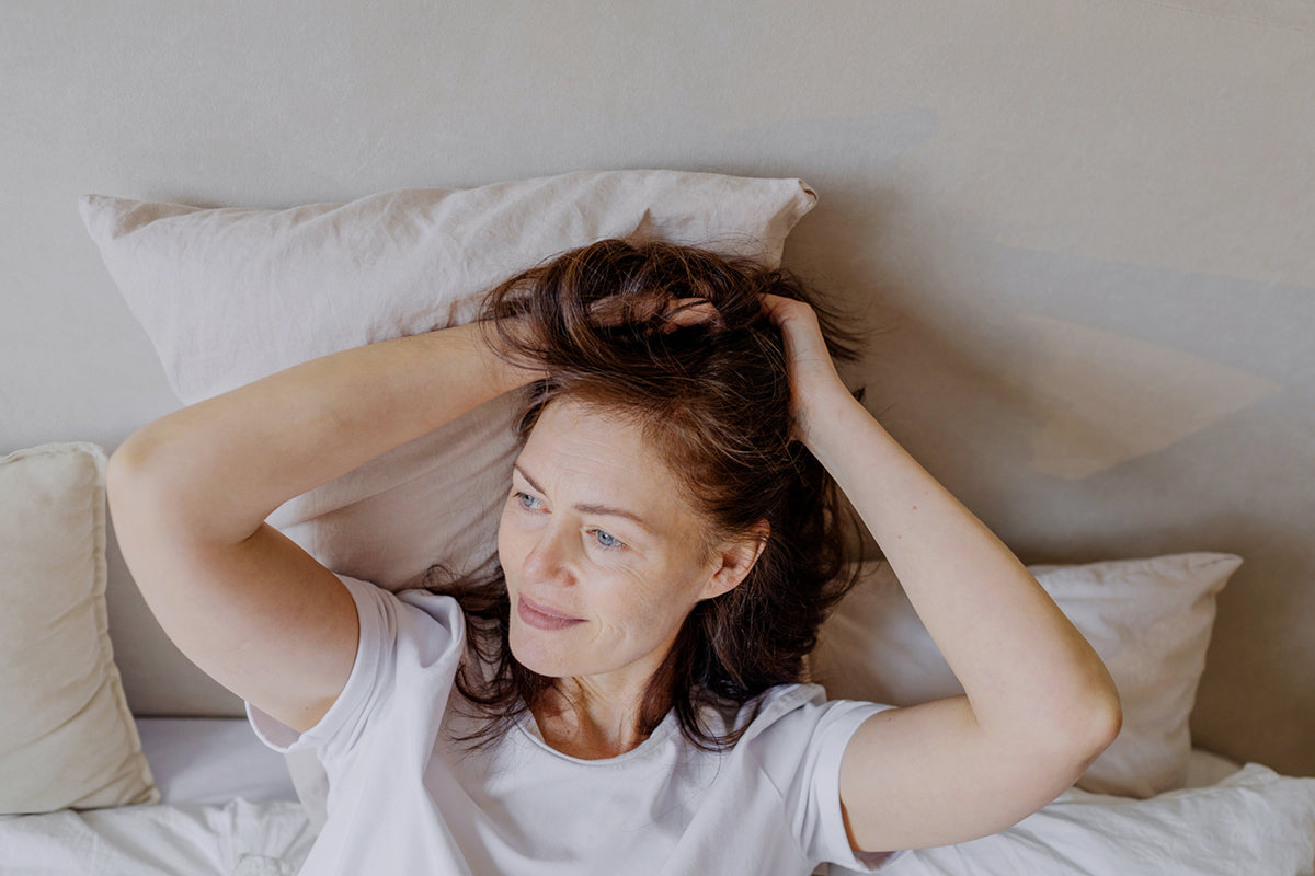 Woman smiling in natural light representing skin health and well-being associated with NAD+ research.